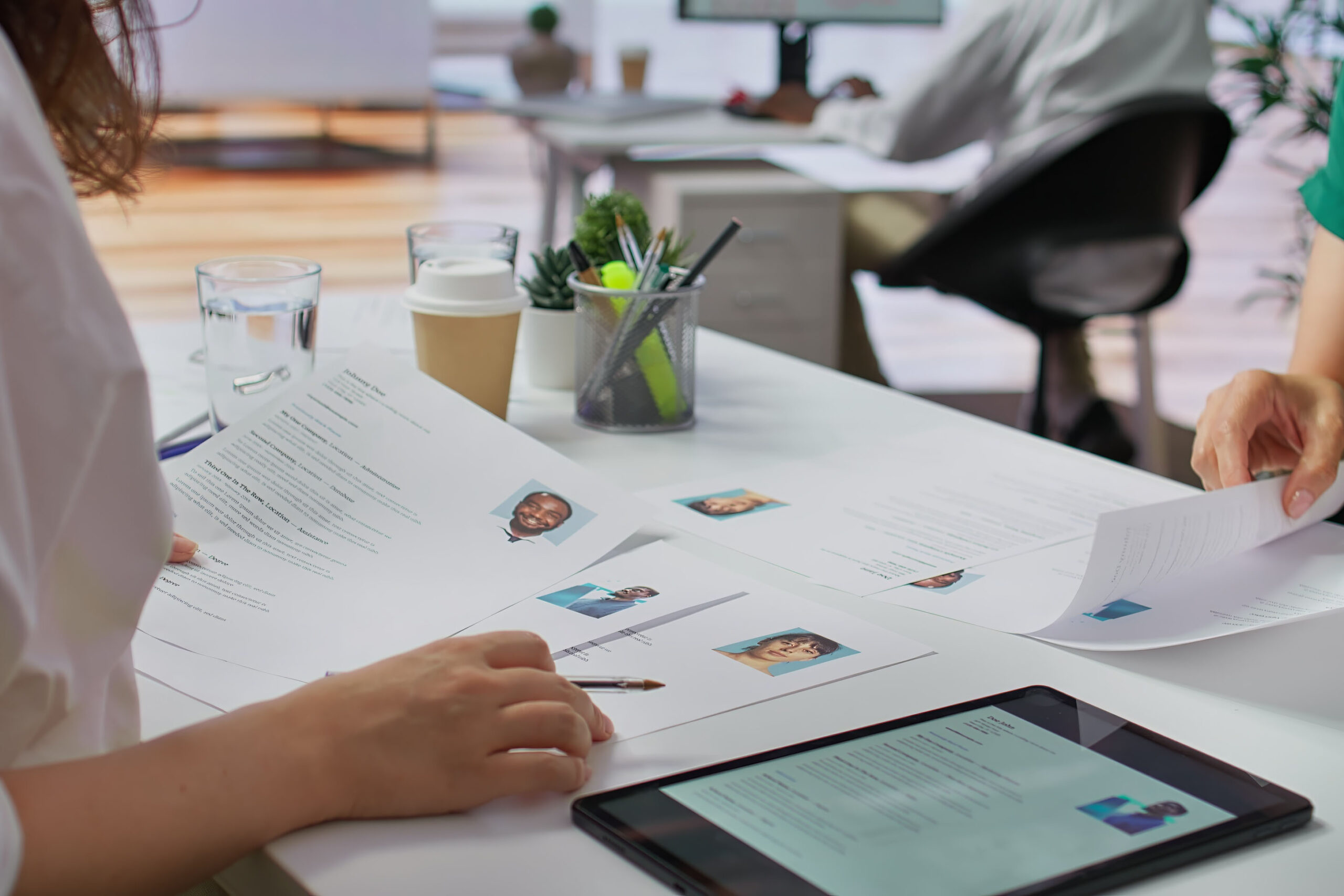 Consultants RH analysant des CV sur un bureau moderne, symbolisant l’externalisation de la gestion du personnel et des ressources humaines